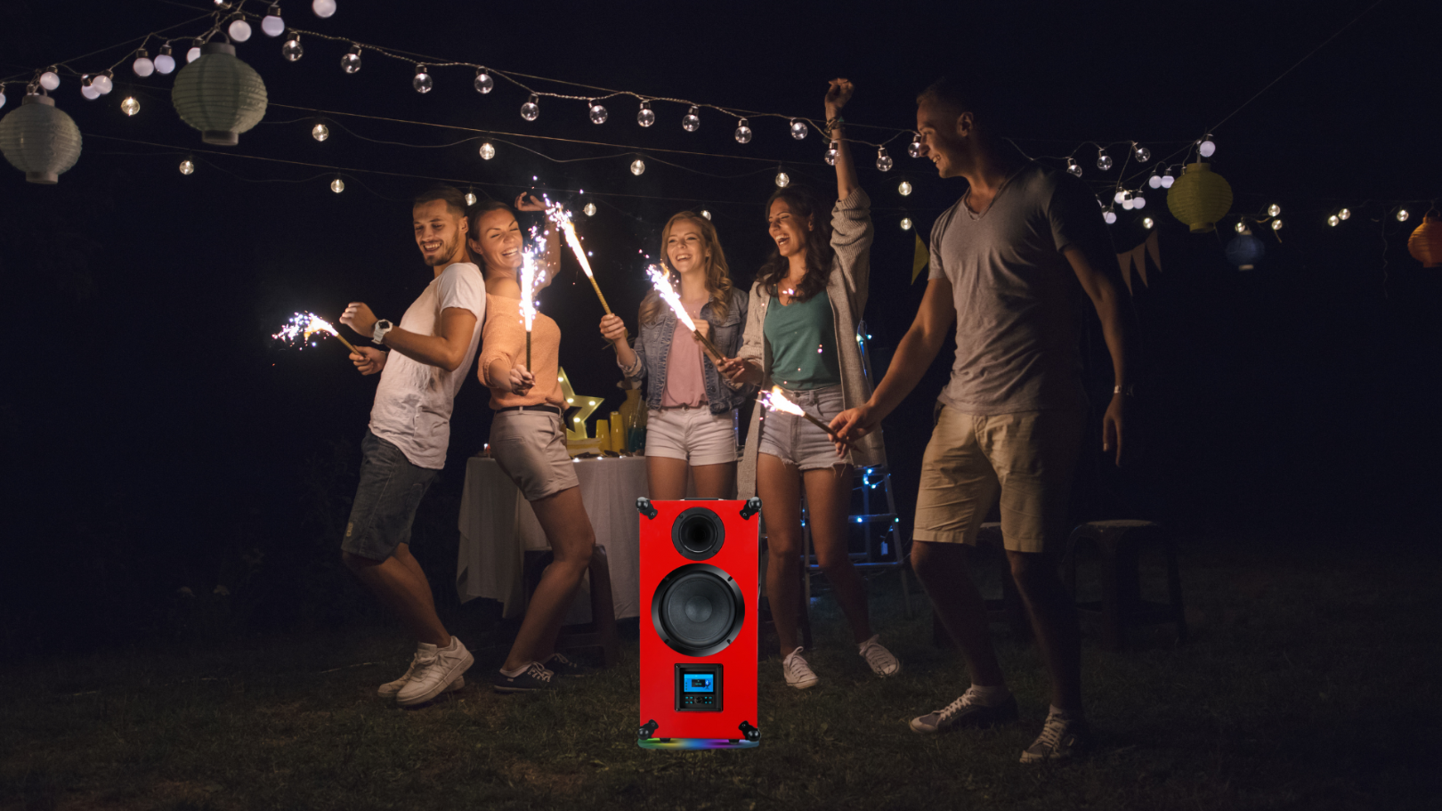 Group of friends with sparklers around a red DioDIY Heartbeat speaker at night. party speaker with colorful LED light